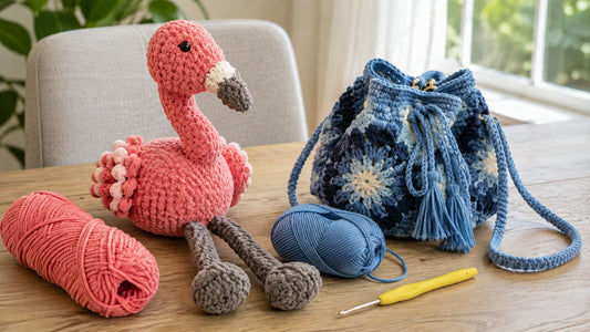 Pink flamingo amigurumi and blue flower granny square bag with contrasting yarn textures on a craft table