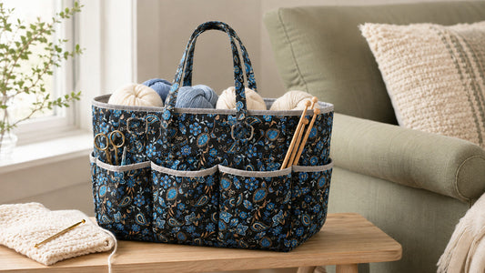 Blue paisley quilted yarn storage tote beside an armchair with yarn and crochet tools