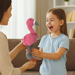 Child receiving a pink flamingo amigurumi plush made with the crochet kit
